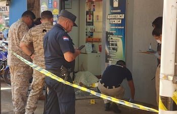 Agentes de la Policía Nacional trabajan en la escena del crimen, frente a la tienda TS Celulares que fue asaltada en la avenida San José del barrio Ciudad Nueva de Ciudad del Este.