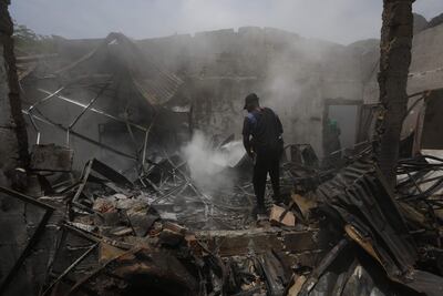 Un hombre usa un extintor en los escombros de una vivienda destruida por un ataque con carro bomba que iba dirigido a una estación policial el pasado miércoles, en la localidad de Timba, Cauca (Colombia). (EFE)