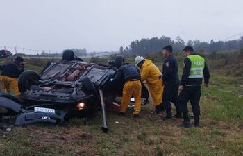 Bomberos y policías trabajan para sacar a las víctimas que viajaban en el automóvil.