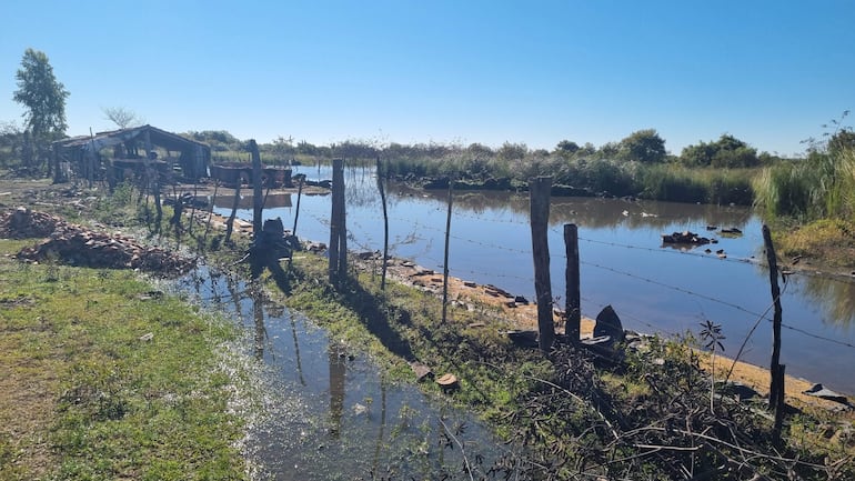 Paisaje rural en Villa Florida, con cuerpo de agua y vegetación, sin personas visibles.
