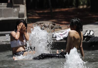 Jóvenes se refrescan en una fuente este viernes en la Ciudad de México (México).
