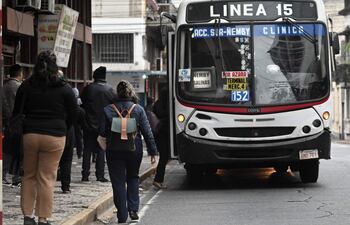 Pasajeros esperando buses del transporte público en la calle Oliva, en el microcentro de Asunción.