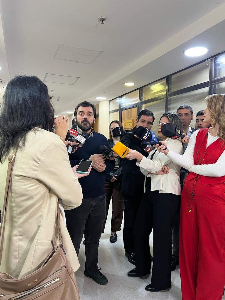 Hombre con suéter oscuro responde preguntas rodeado de periodistas en el interior del Congreso Nacional, con micrófonos en mano.