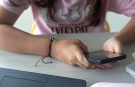 Una niña manipula un teléfono celular
