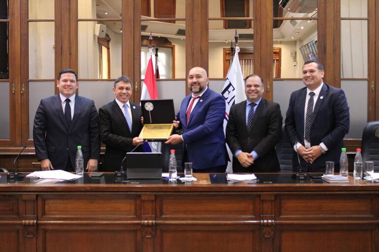 Oscar Paciello recibe una plaqueta de reconocimiento a su labor en el JEM, de parte de su presidente Orlando Arévalo. También aparecen en la foto los legisladores Alejandro Aguilera, Mario Varela y Derlis Maidana.