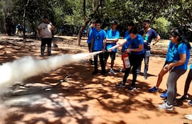 Los chicos practican la forma correcta de usar un extintor para apagar una incendio.