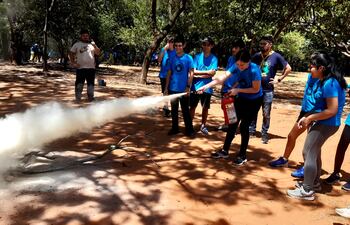 Los chicos practican la forma correcta de usar un extintor para apagar una incendio.