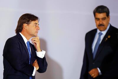 El presidente de Uruguay, Luis Lacalle Pou (i) con el rostro serio, lo sigue de cerca el mandatario venezolano Nicolas Maduro (d). (AFP)