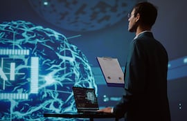 Empleado de una startup revisando gráficos empresariales y utilizando software de IA para tomar decisiones basadas en datos en el sector tecnológico.