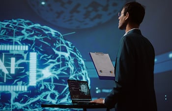 Empleado de una startup revisando gráficos empresariales y utilizando software de IA para tomar decisiones basadas en datos en el sector tecnológico.