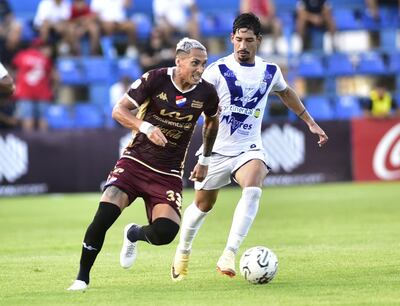 Orlando Gaona Lugo (i), futbolista de Nacional, pelea por el balón con Aldo Maíz, jugador de Sportivo Ameliano, en un partido de la primera fecha del torneo Apertura 2024 del fútbol paraguayo, en el estadio Luis Alfonso Giagni, en Villa Elisa.