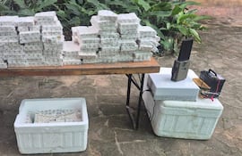 Paquetes de medicamentos organizados sobre mesa de madera, sin personas visibles, en un entorno natural.