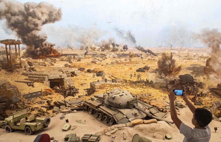 Un niño toma fotografías de una recreación de una batalla de la guerra de Yom Kippur en un museo en El Cairo, Egipto.