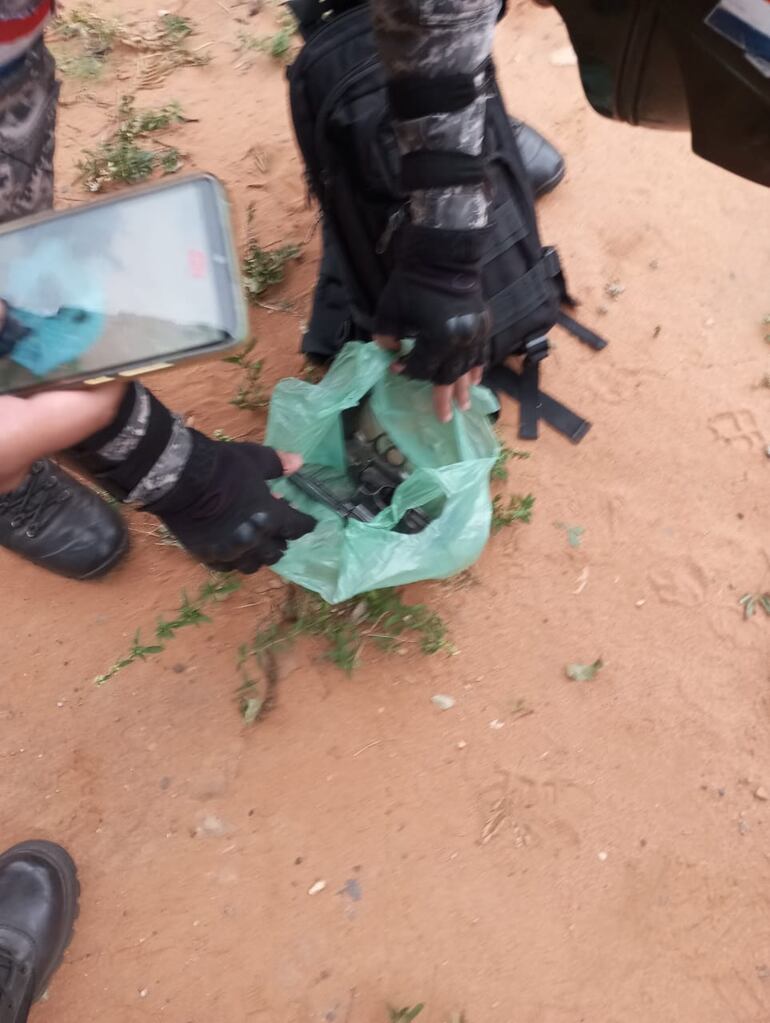 Un efectivo policial enseña los dos revólveres confiscados a los asaltantes capturados.