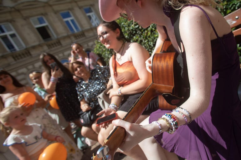 Fans de Taylor Swift cantando alrededor del "árbol swiftie" en Cornelius Strasse en Vienna, Austria.