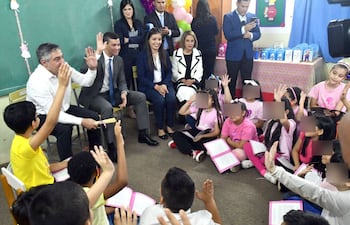 Luis Ramírez, ministro de Educación y Santiago Peña, presidente de la República leen libros a estudiantes.