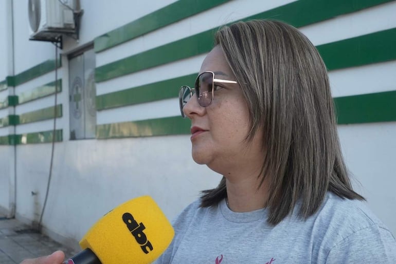 María Chamorro con gafas de sol y camiseta gris, sostiene un micrófono mientras dialoga atentamente.