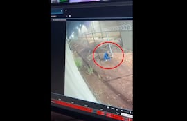 Uno de los reos fugados cortando el tejido intermedio entre el patio y el muro perimetral, durante el escape del penal de Minga Guazú, en la madrugada de este lunes.