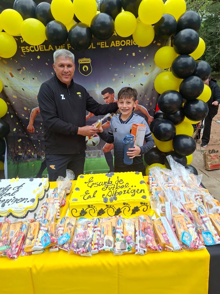 El profesor Edelio Lezcano entregando obsequios a uno de los chicos de la escuela.