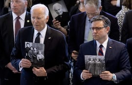 El presidente estadounidense Joe Biden (izquierda) y el presidente de la Cámara de Representantes, Mike Johnson (derecha), sostienen fotografías de personas que murieron durante el Holocausto en la ceremonia de los Días de Recuerdo del Museo Conmemorativo del Holocausto de Estados Unidos. En el Capitolio de los Estados Unidos en Washington, DC.