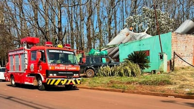 Camión de bomberos de Encarnación estacionado, con inmueble verde dañado al fondo y árboles desnudos en el ambiente.