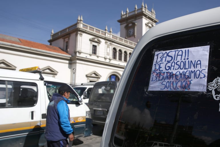 Una persona camina junto a vehículos que bloquean la vía durante una protesta este miércoles, en La Paz (Bolivia).