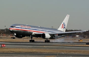 Un avión de la aerolínea American Airlines aterrizando en pista.