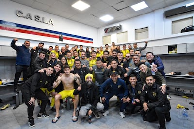 Los jugadores, miembros del cuerpo técnico, componentes de la comisión directiva e integrantes del staff de Recoleta FC, posan en el vestuario del Nuevo Gasometro, tras obtener el histórico paso a los octavos de final de la Copa Sudamericana.