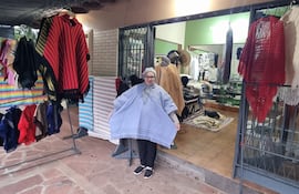 Máxima González, exhibiendo su poncho, que hace juego con su bufanda y gorra, y que está a la venta en su negocio denominado Artesanía Mainumby.