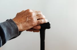 Manos de anciano con bastón.