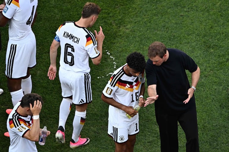 El seleccionador de Alemania Julian Nagelsmann habla con el defensa #18 Nathaniel Brown durante la pausa de hidratación del partido de fútbol de los dieciseisavos de final de la Copa del Mundo 2026 entre Alemania y Paraguay en el Boston Stadium en Foxborough.