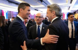 Peña en traje azul observa a Alter y Abdo Benítez en trajes oscuros, todos sonriendo en un ambiente decorado con rojo, blanco y azul.