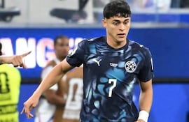 Futbolista paraguayo con camiseta azul oscuro y número 7, en acción en el campo durante un partido.