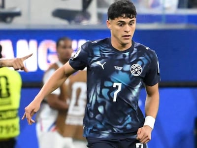 Futbolista paraguayo con camiseta azul oscuro y número 7, en acción en el campo durante un partido.
