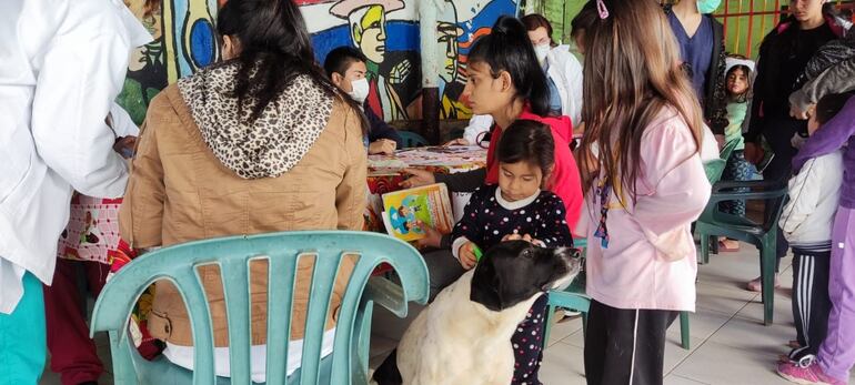 La pequeña Brenda jugando con Buquilla, quien no la abandona durante el chequeo médico.