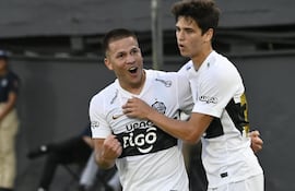 El volante de Olimpia, Hugo Quintana celebra el segundo tanto de su equipo, acompañado por el juvenil Eduardo Delmás.