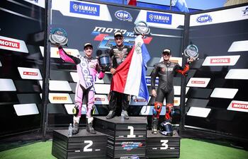 El paraguayo Pedro Valiente posa con su trofeo y la bandera tricolor en alto.
