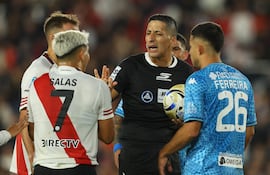 El árbitro Yael Falcón discute con el delantero número 07 de River Plate, Maximiliano Salas, y el defensor paraguayo número 26 de Tucumán, Clever Ferreira, durante el partido del Torneo Apertura 2026 de la Liga Argentina de Fútbol Profesional entre River Plate y Atlético Tucumán, en el estadio Mas Monumental de Buenos Aires, el 3 de mayo de 2026. (Foto de ALEJANDRO PAGNI / AFP)