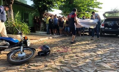 Agentes policiales realizan el análisis de la escena. Vecinos del lugar retiran en camilla a uno de los muertos.