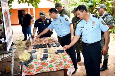 El comisario general Domingo Noldin (i) y el comisario  principal Carlos Leiva observan las evidencias encontradas en el cateo.