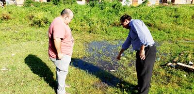 Miembros de Sinadi muestran la acumulación de agua y yuyales que se forman en la Escuela Básica 4902 Priv. Subv. Santa Rosa de Lima. en el Bañado Sur. Varias instituciones están igual.