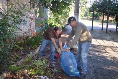 Dos personas apoyan las tareas de limpieza en Villa Elisa.