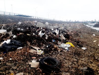 El muro entre la bahía y la Costanera Norte sirve de depósito de basura generada por  damnificados  por la subida del río Paraguay, reubicados en zona del ingreso al Club El Mbiguá. El descenso de agua dejó al descubierto vertederos.