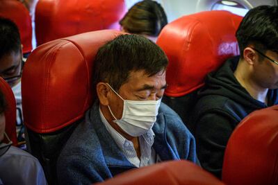 Un pasajero con tapabocas en un avión en el Aeropuerto Internacional de Yangon, China.