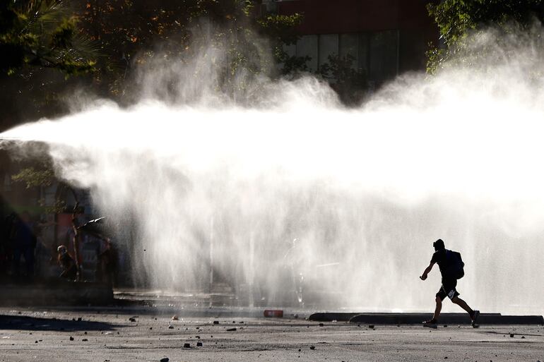 Fuerzas Especiales de Carabineros dispersan a un grupo de manifestantes este domingo en la céntrica plaza Italia de Santiago (Chile), rebautizada popularmente como Plaza de la Dignidad, durante una jornada de movilizaciones en todo el país en contra del Gobierno y en demanda de mejoras sociales de corte transversal.