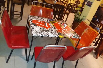 Un comedor hecho con la chapería y los asientos de la chatarra de un colectivo.