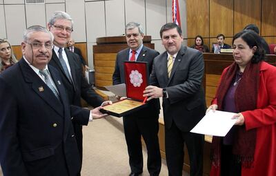 Momento en que el presidente de la Cámara de Senadores, Blas Llano, hace entrega del reconocimiento al Dr. Isaías Fretes.