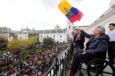 El presidente ecuatoriano Lenin Moreno ondea una bandera desde un balcón del Palacio de Carondelet, en Quito.