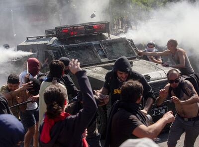Manifestantes hicieron frente a un vehículo antimotines, ayer, durante la quinta jornada de protestas violentas.
