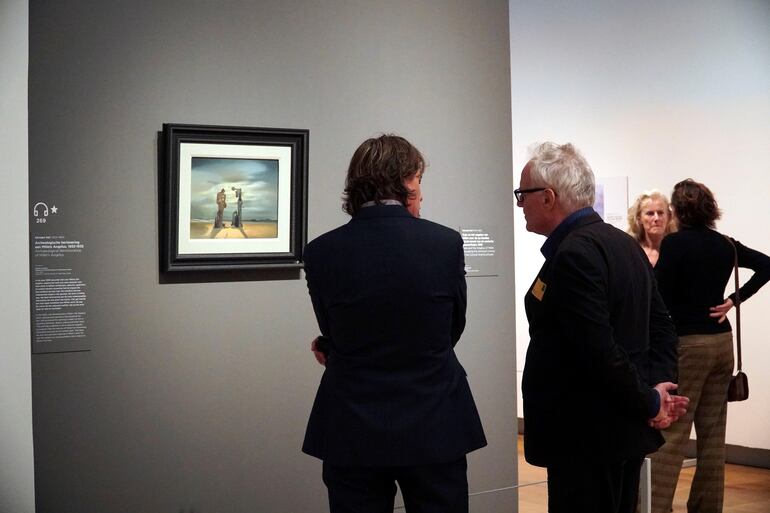 Dos asistentes analizan un cuadro de Dalí, inspirado en ''El Ángelus'' del artista francés Jean-François Millet (1814-1875).